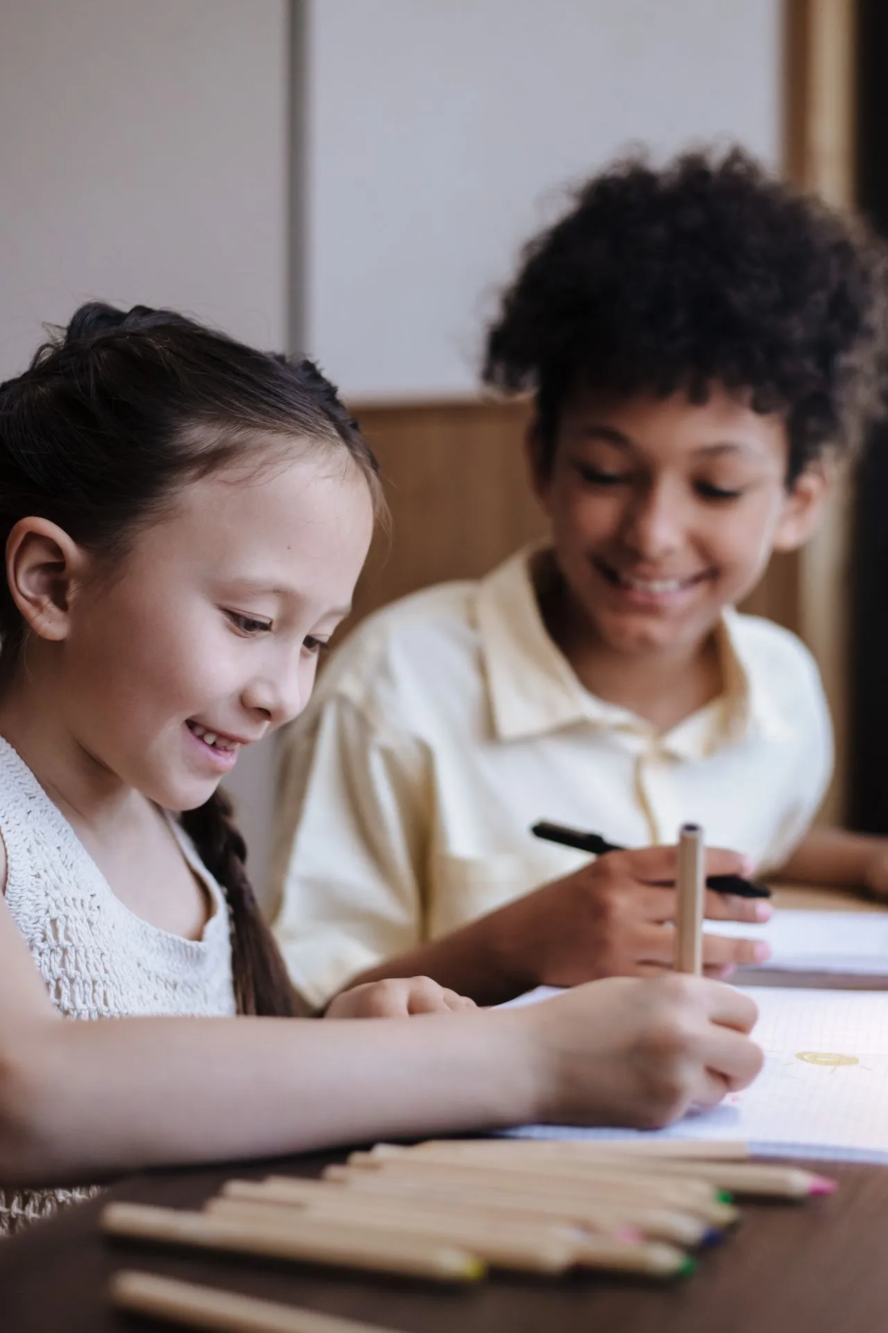 Two children focused on a writing and drawing activity